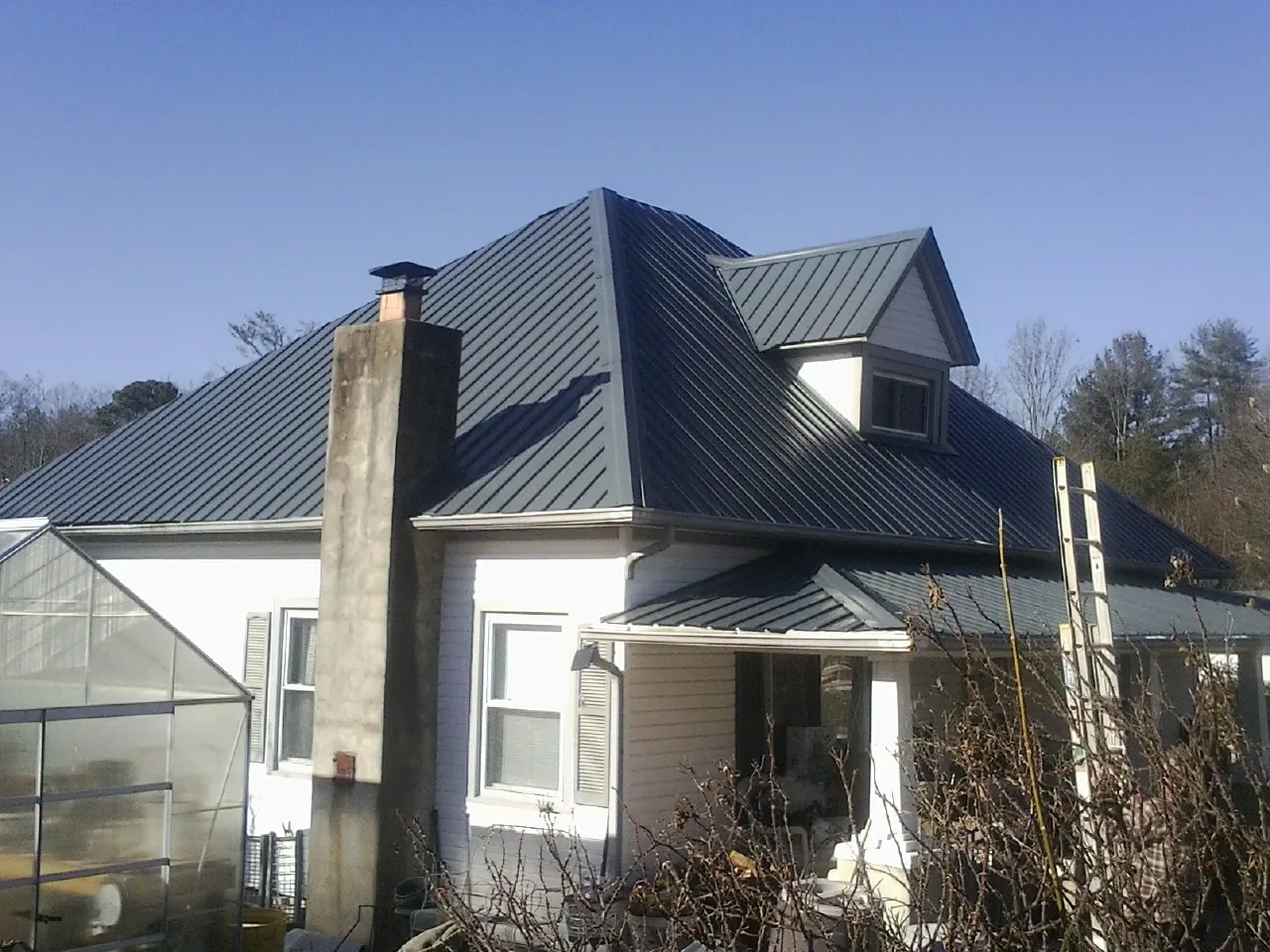 Dark blue standing seam metal roof on a white farmhouse with dormer — Slate & Tile Roof Repair by Roofing Brothers in Fort Thomas