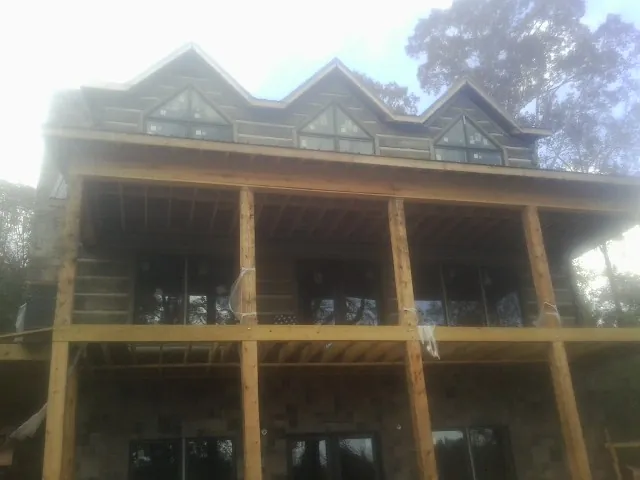 Dormers and porch framing on a large log home under construction — Roof Coating work by our crew in Fort Thomas