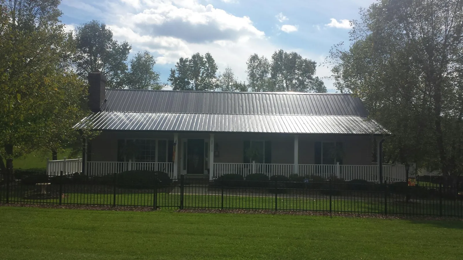 Gray metal roof on a brick ranch with a full width front porch — Gutter Guard Installation work by our crew in Fort Thomas